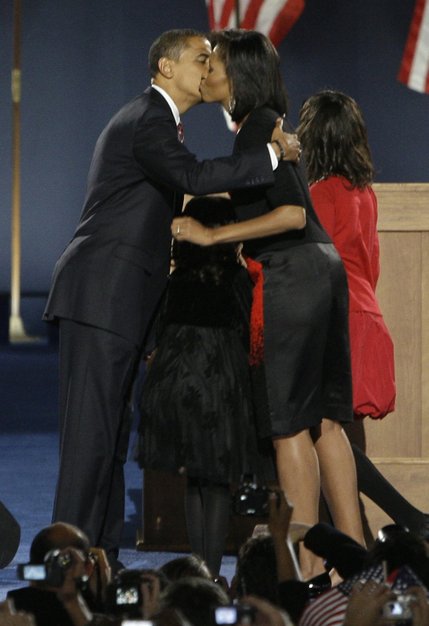 President-elect Barack Obama kisses his wife, Michelle, as daughters Malia, right, and Sasha, look on at his election night party at Grant Park in Chicago, Tuesday night, Nov. 4, 2008. 