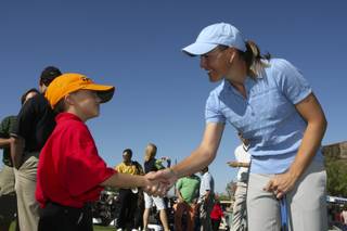 Excited to meet a professional golfer, volunteer Matthew Manganello, 7, shakes the hand of LPGA player Stephanie Louden during the Danny Gans' Partee Fore Kids Celebrity Pro-Am at DragonRidge Country Club on Monday.