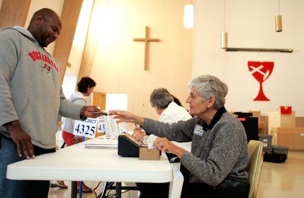 Paris Riley, left, 32, a music studio owner, gets his voting card from edge worker Lynda Price on election day at First Christian Church on South Rancho Drive in Las Vegas Tuesday.