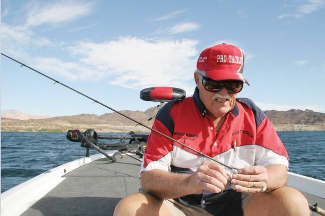 Local angler Mike Sisco hooks grub bait to his fishing line as he prepares to fish Sunday at Lake Mead.