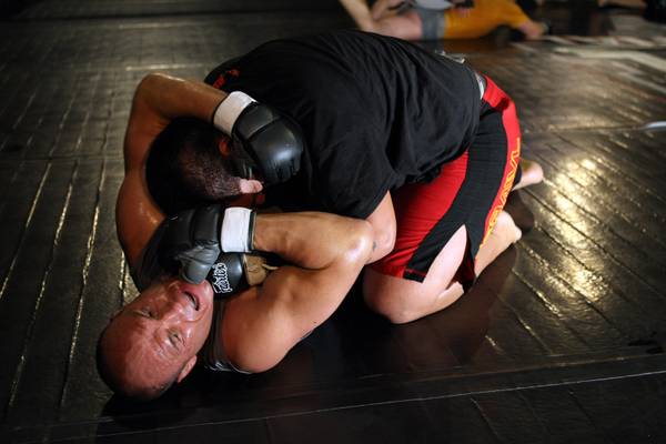Mixed martial arts fighter Randy Couture, bottom, wrestles with Brice ...