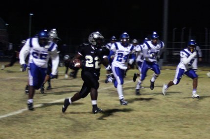 Palo Verde's Chaz Thomas (22) runs the ball while being chased by a crowd of Sierra Vista defenders.