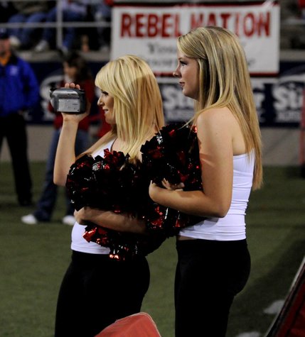 Jill Welch shoots video of the Rebel Girls as they perform during the first half of Saturday's football game between UNLV and New Meico. Fellow Rebel Girl Allie Popeisky looks on. 