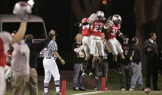 The Rebels, from left, Rodelin Anthony, Terrance Lee and David Biggs, celebrate a blocked punt they returned for a touchdown against New Mexico.