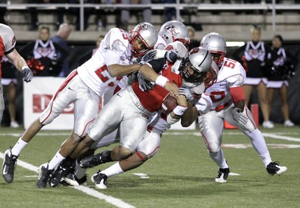 Four New Mexico players help in sacking UNLV quarterback Mike Clausen.