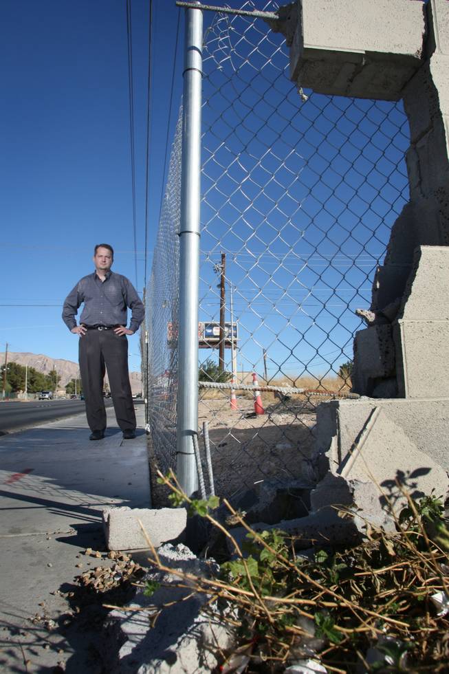 Martin Dean Dupalo shows a damaged wall on East Charleston Boulevard. To make his case against Wal-Mart selling alcohol, Dupalo took pictures of nearly three dozen sites in his Las Vegas neighborhood where drunken drivers have caused property damage. 