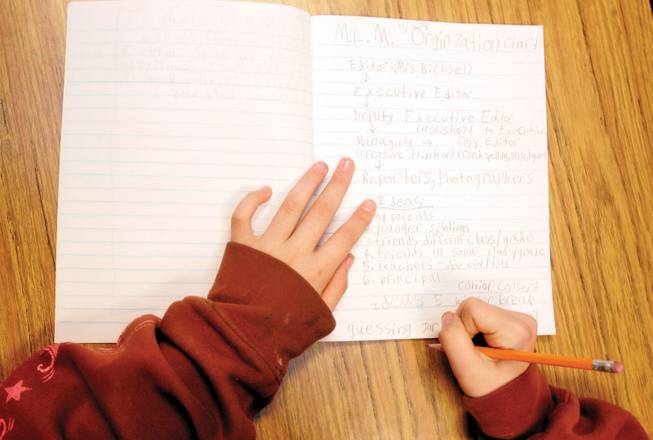 Lily Mullis writes possible story ideas down in her journal for Nate Mack Elementary School's new newspaper Mountain Lion Monthly.
