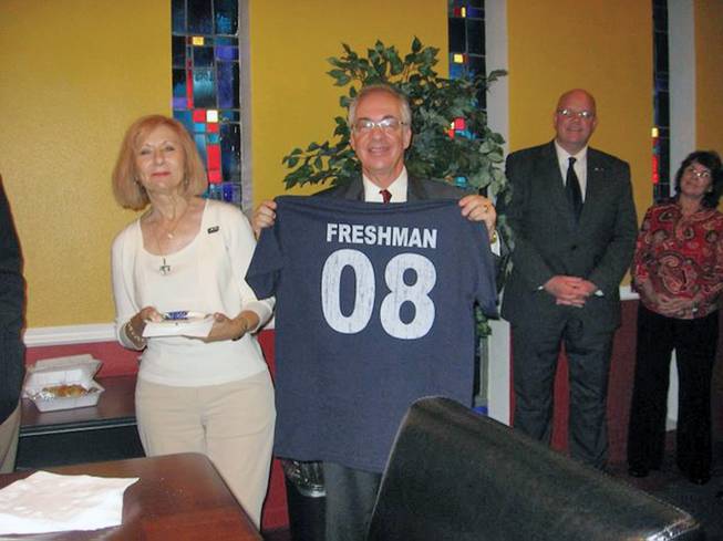 Summerlin resident Steve Lake, right, holds up a shirt representing the status of "permanent freshman" he was granted at Our Lady of the Lake University in San Antonio, Texas. The university was Lake's 500th college visit in 20 years.