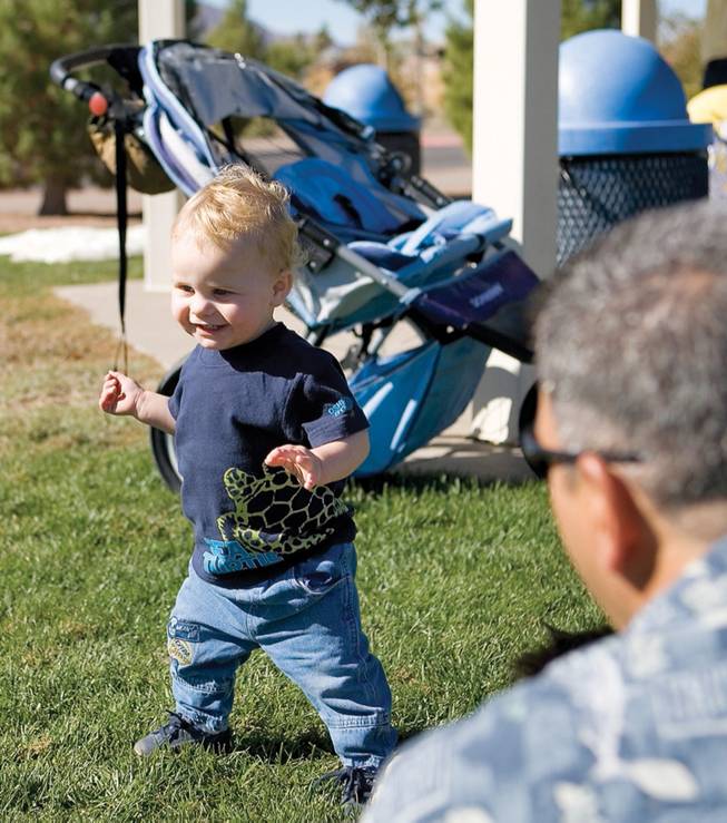 Sam Dingman, 1, walks past his father Wayne Dingman at a picnic in celebration of families with adopted children.