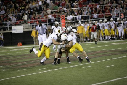 Three members of Wyoming's defense wrap up UNLV receiver Casey Flair.