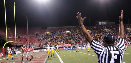 The referee signals a touchdown as UNLV celebrates in the end zone.