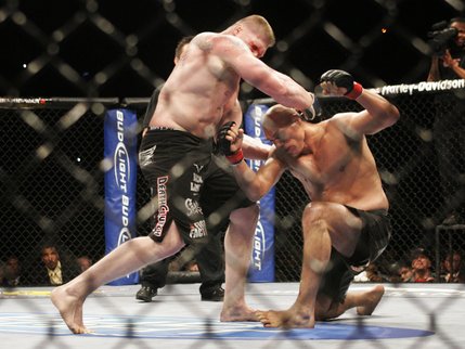 Brock Lesnar, left, drives Randy Couture to the mat in the second round of their title fight Saturday at the MGM Grand Garden Arena. Lesnar finished Couture off moments later with a flurry of punches to become the UFC's new heavyweight champ.