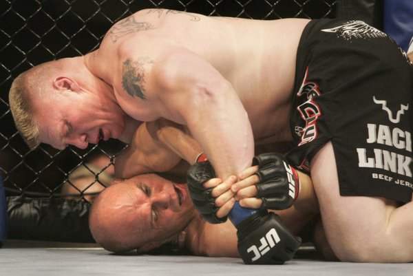 Brock Lesnar works one of Randy Couture's pressure points during ...