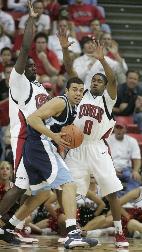 UNLV forward Brice Massamba, left, and guard Oscar Bellfield pressure ...