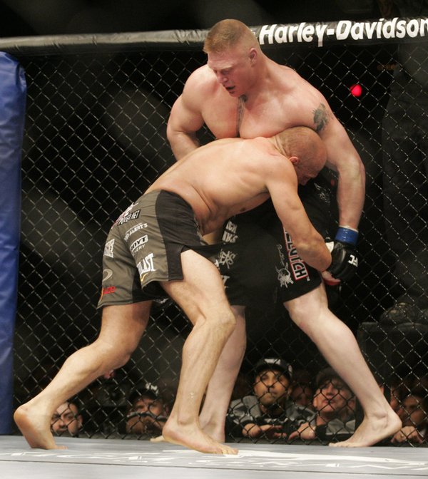 Randy Couture drives Brock Lesnar to the fence during the ...