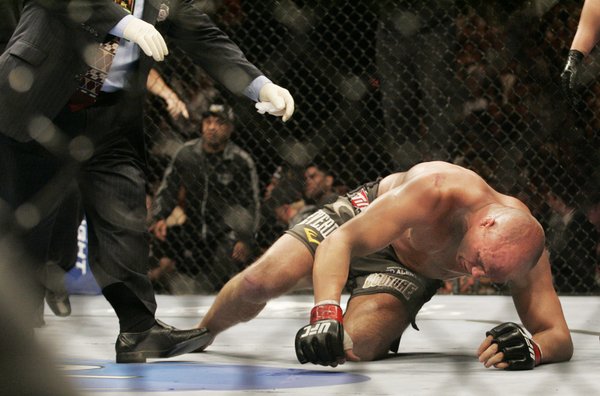 Heavyweight champion Randy Couture struggles to get up after enduring ...
