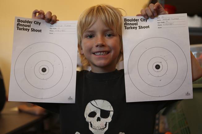 After scoring an average of 33 out of 80 possible points, Justice Tilman, 7, proudly holds up his targets showing his BB hits Tuesday during the annual Turkey Shoot at the Boulder City Recreation Center.