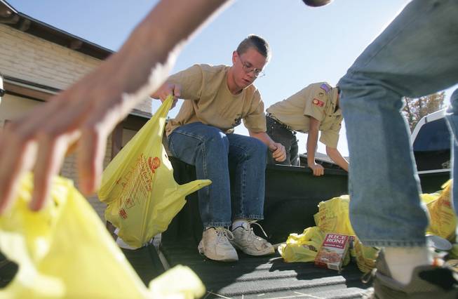 Boy Scout Chris Pearce unloads bags of donated food from the Boy Scouts' holiday food drive at the Emergency Aid office in Boulder City to be sorted on Saturday.