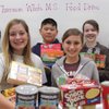 From left to right, members of the Thurman White Middle School student council and National Junior Honor Society Lakshmeeramya Malladi, Allessandra Brice, Anthony Ku, Lindy Eskin, Ariana Marciel and Linh Foschi hold armfuls of food collected for the holidays.