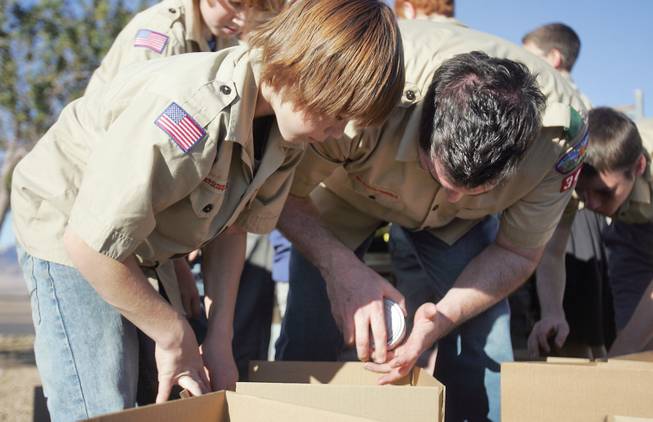 Weston Little, left, and Jason Leavitt, from Troop 344, sort donated food collected as part of the Boy Scouts' holiday food drive at the Henderson Salvation Army on Saturday.