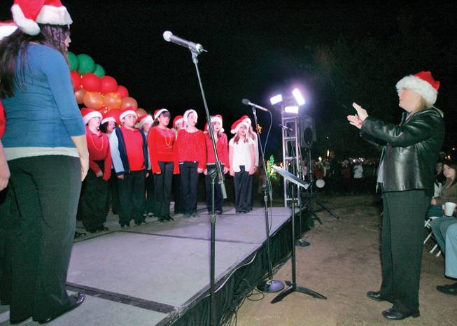 Director Debby Fleischer, right, directs the Schofield Middle School choir Nov. 11, 2008, at the eighth annual Gift of Lights holiday light festival at Sunset Park.