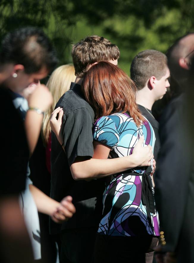 Mourners embrace Wednesday during funeral services for Olivia "Lynn" Brandise Hyten at Palm Mortuary in Green Valley. 