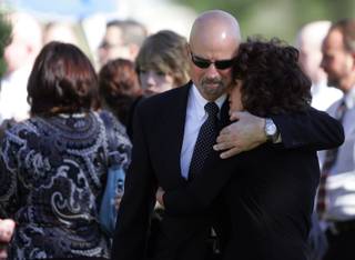Mourners embrace at the Wednesday funeral of Olivia 