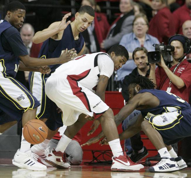 UNLV forward DeShawn Mitchell loses the ball under pressure from Northern Arizona's Shayar Lee, left, Matt Johnson, center, and Jermaine Calvin during the second half of the Nov. 20 game.