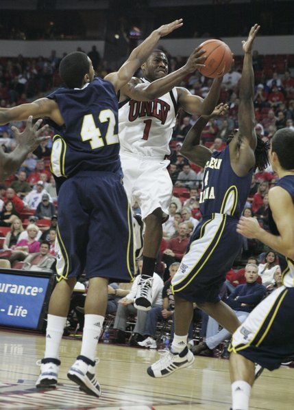 UNLV guard Wink Adams drives past Northern Arizona's Josh Lepley, left, and Jermaine Calvin during the second half of their game Thursday. Adams finished with a game high 18 points as UNLV won the game 87-71 to improve to 3-0.