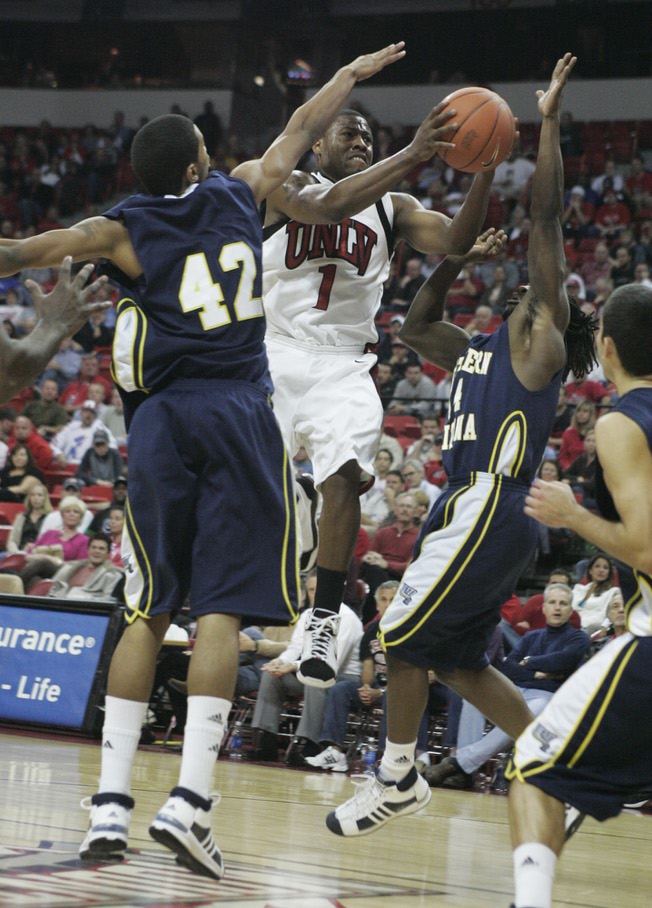 UNLV guard Wink Adams drives past Northern Arizona's Josh Lepley, left, and Jermaine Calvin during the second half of their game Thursday. Adams finished with a game high 18 points as UNLV won the game 87-71 to improve to 3-0.