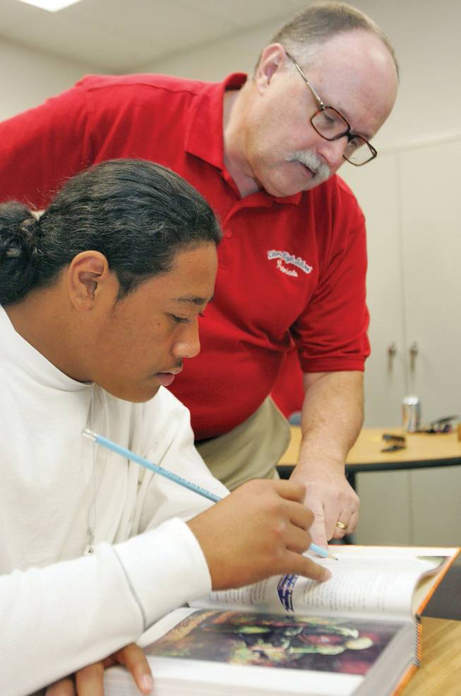 Wayne Renderman, a teacher at Liberty High School, helps Daniel Filimona with an English assignment at the new learning laboratory at the school.