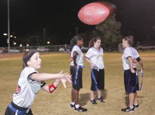RaeAnn Brems, 12, passes a football to a teammate while running through a drill during WASUP youth flag football practice on Nov. 11 at Silvestri Middle School Park. Brems's team is one of two WASUP youth flag football teams to advance to the NFL flag football championships in Florida on Saturday.