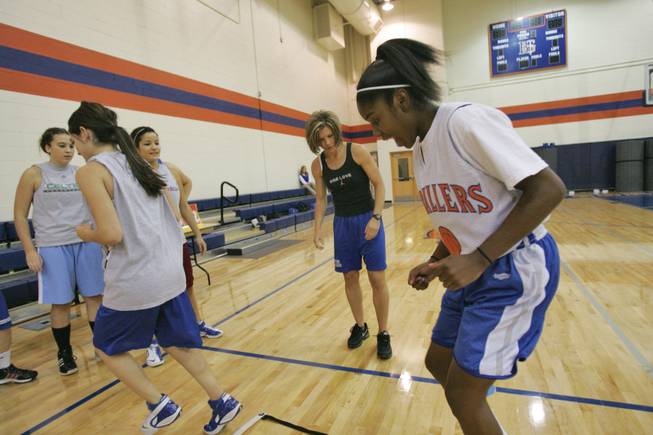 Bishop Gorman junior basketball player Aaryn Ellenberg, 16, right, works on foot drills as coach Sheryl Krmpoti, center, looks on during a team practice in the school's auxiliary gym.
