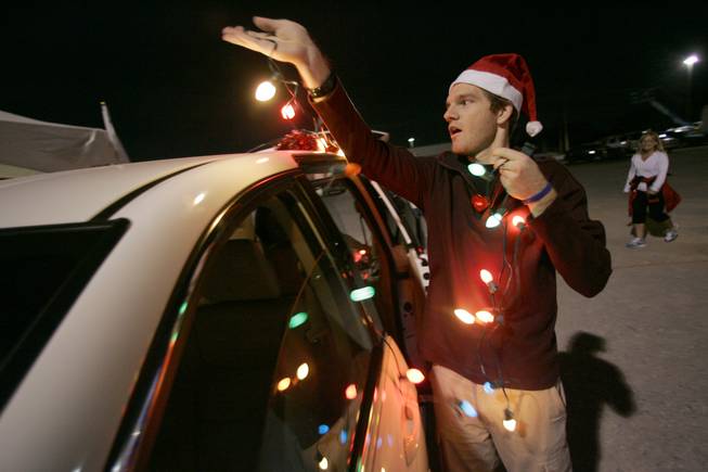 Volunteer Sean Daniel wraps a van in Christmas lights Nov. 11, 2008, during the eighth annual Gift of Lights holiday festival at Sunset Park.