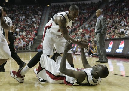 UNLV guard Wink Adams helps up teammate Beas Hamga after he hit the deck during the first half of their game Nov. 22 against North Carolina A&T at the Thomas & Mack Center. 