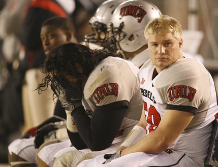 UNLV's Malo Taumua, center, holds his head in his hands as he sits on the bench late in the fourth quarter during the game against San Diego State on Saturday. San Diego State won 42-21. 