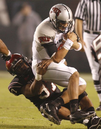 UNLV quarterback Mike Clausen, right, is tackled by San Diego State's Eric Ikonne, left, for a 2-yard loss on a quarterback keeper during the first quarter Saturday in San Diego. 