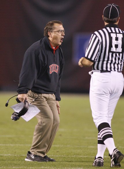 UNLV coach Mike Sanford, left, challenges a call as an official looks on during the first quarter of UNLV's game against San Diego State.