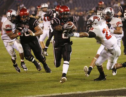 San Diego State running back Atiyyah Henderson, center, holds the ball out as he beats UNLV's Terrance Lee (23) into the end zone on a 12-yard pass reception during the fourth quarter Saturday in San Diego.  San Diego State won 42-21.