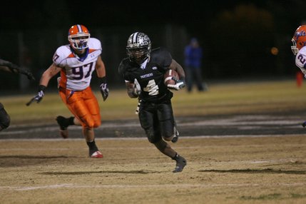 Palo Verde's Sidney Hodge (4) runs through Bishop Gorman defenders during the Sunset Regional championship game at Palo Verde Friday.