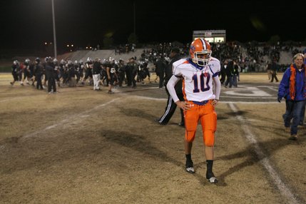 Palo Verde players celebrate in the background as Bishop Gorman quarterback Joe Huber (10) walks off the field after losing the Sunset Regional championship game Friday night 50-14.