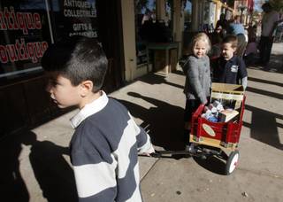 From left to right: With the help of fellow Grace Christian Academy students Abbi Matthews, center, and Ian McConnhie, right, Julian Estorga pulls a wagon full of food to donate to Emergency Aid for Thanksgiving meals on Friday.