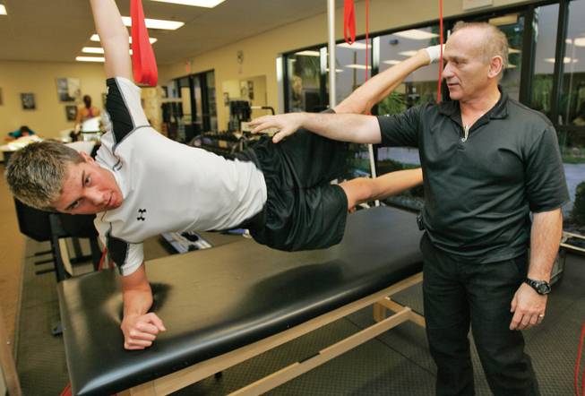 Physiotherapist Bob Donatelli, National Director of Sports Specifics Rehabilitation and Performance Enhancement, works with patient Caleb Cline, 16, a Las Vegas High swimmer rehabilitating from a femur injury.