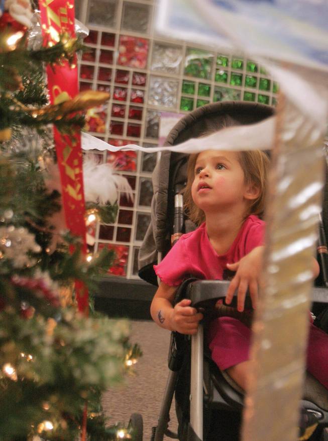Sarah Sprole looks with wonder at decorated trees on display at Paseo Verde Library as part of its Library Tree Lane showcase.  
