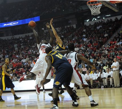 Brice Massamba of UNLV forces a shot up over Max Zhang of California Friday at the Thomas & Mack Center.