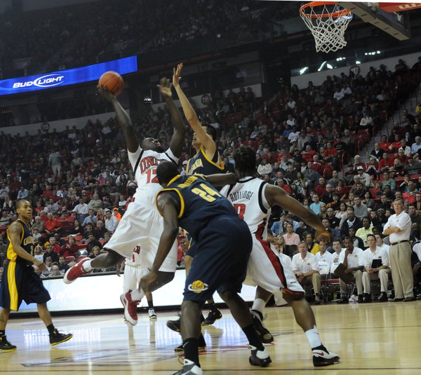 Brice Massamba of UNLV forces a shot up over Max ...