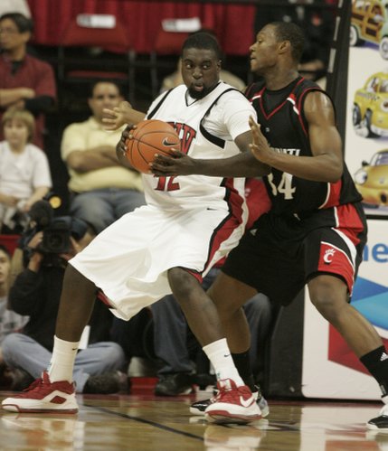 UNLV forward Brice Massamba gets pressure from Cincinnati forward Yancy Gates during the first half of the game Saturday at the Thomas & Mack Center. 