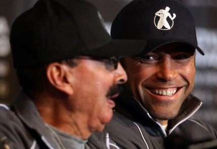 Boxer Oscar De La Hoya, right,  talks with his trainer Ignacio 