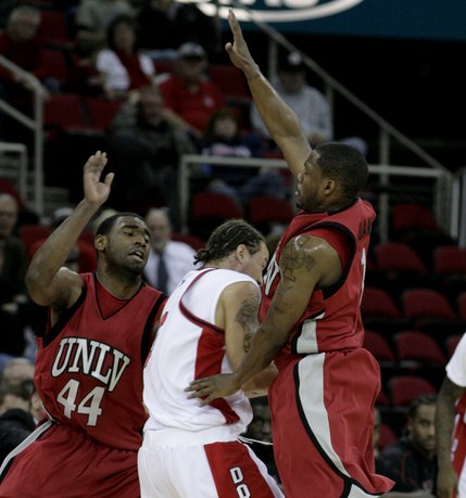 Wink Adams and Darris Santee of UNLV play defense on Dwight O'Neil at the Save Mart Center in Fresno, Calif.