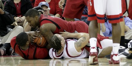 Wink Adams and Oscar Bellfield of UNLV dive for a loose ball Wednesday night as the Rebels take on the Fresno State Bulldogs at the Save Mart Center in Fresno, Calif.